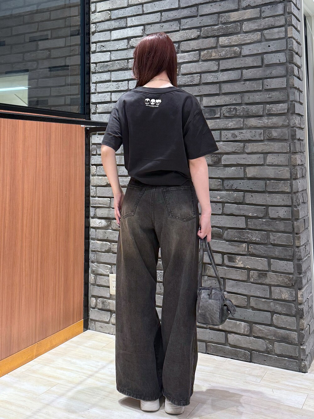 ブラック系のデニムパンツ、ブラック系のボストンバッグを着用したレディースの春コーディネートの3枚目の写真