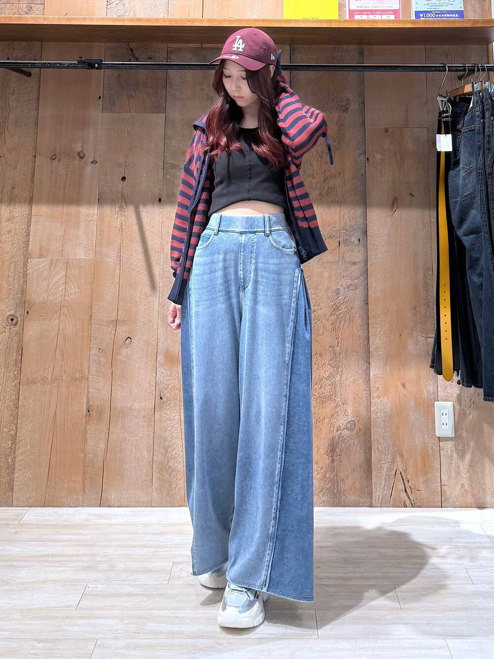 ブルー系のデニムパンツ、シルバー系のスニーカー、ブラック系のタンクトップを着用したレディースの夏コーディネートの2枚目の写真