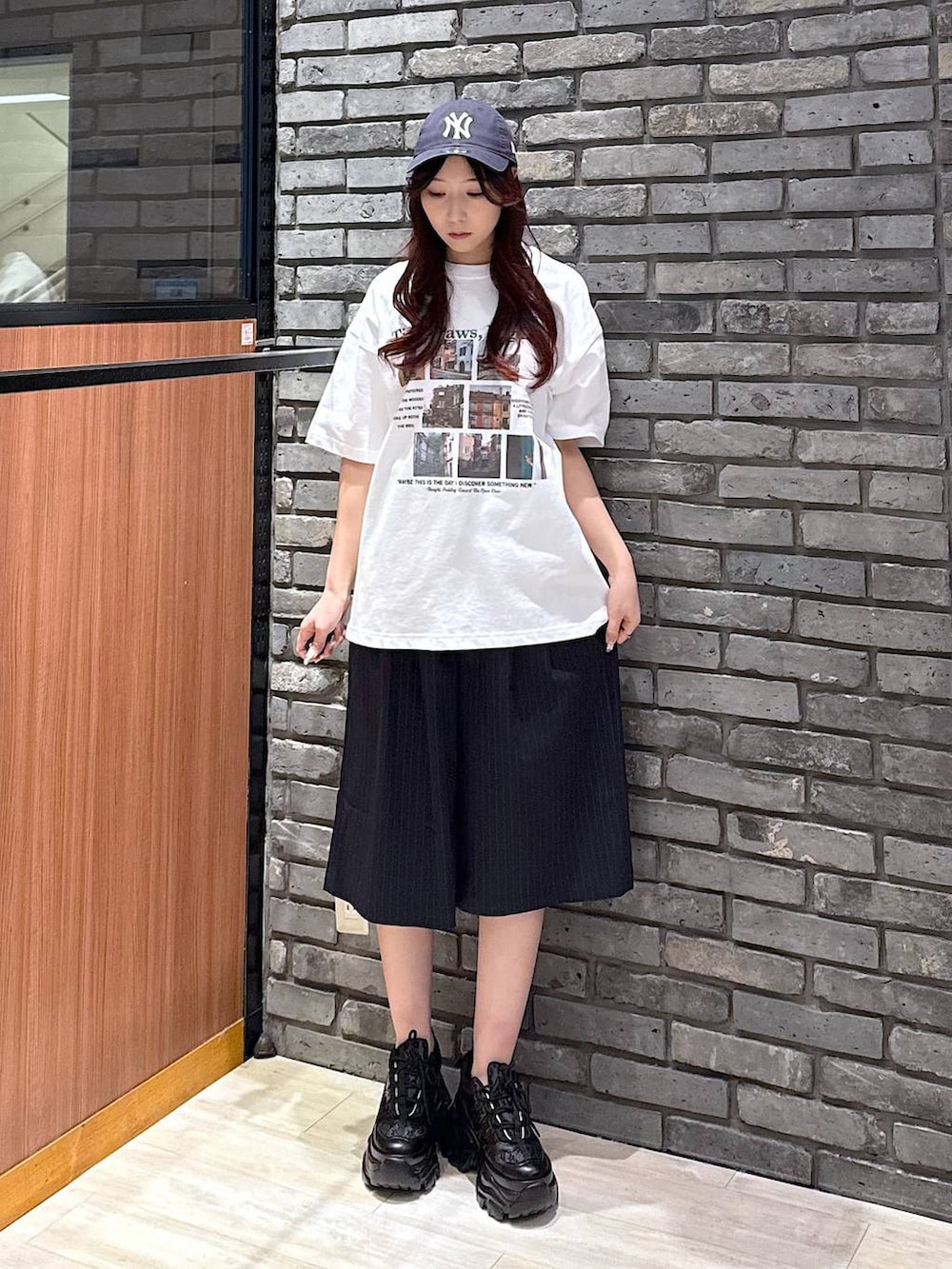 ブラック系のスニーカー、ホワイト系のTシャツ/カットソー、ブルー系のスラックスを着用したレディースの春コーディネートの4枚目の写真