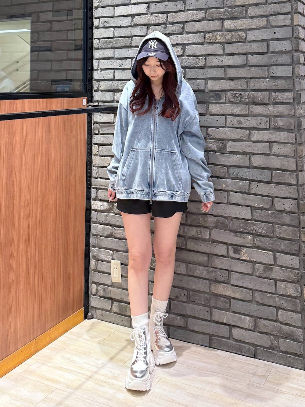 ホワイト系のブーツ、ブルー系のパーカー、ブラック系のスラックスを着用したレディースの春コーディネートの3枚目の写真