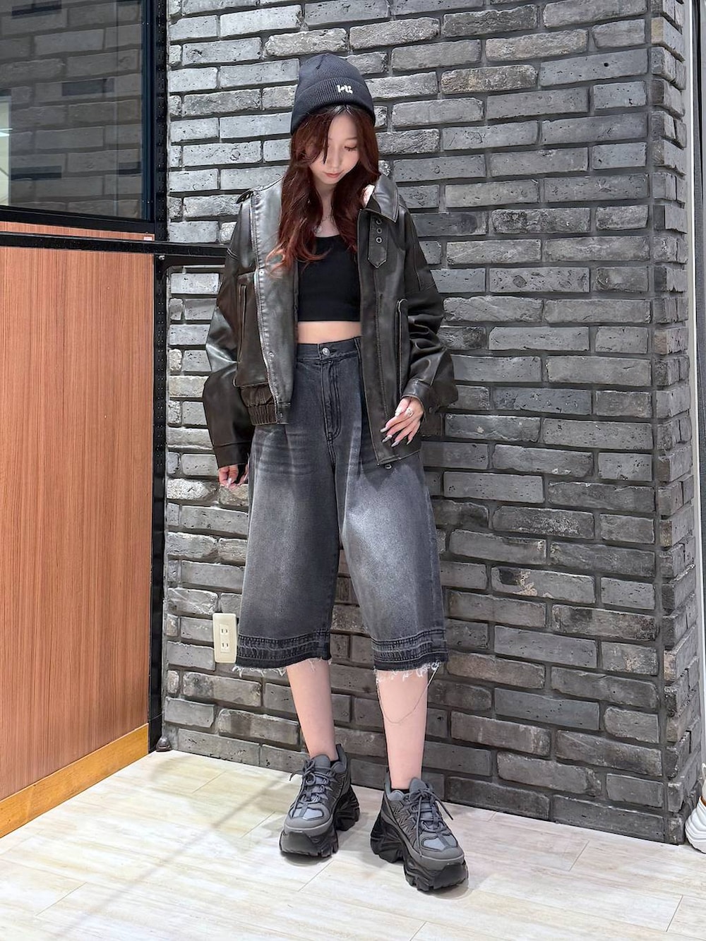 グレー系のスニーカー、ブラック系のデニムパンツ、ブラック系のブルゾンを着用したレディースの秋コーディネートの3枚目の写真