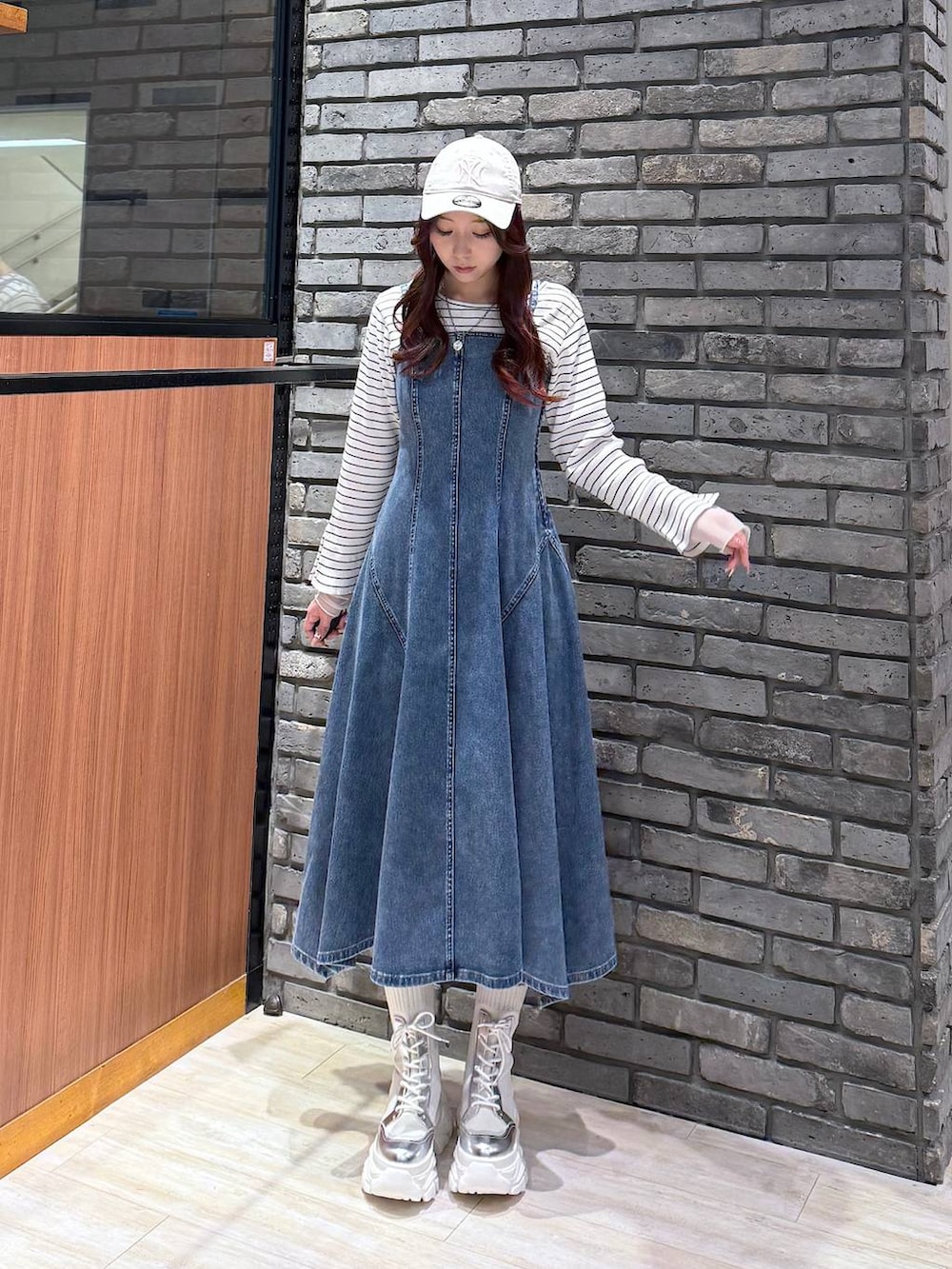 ホワイト系のブーツ、ホワイト系のTシャツ/カットソー、ブルー系のワンピースを着用したレディースの冬コーディネートの4枚目の写真