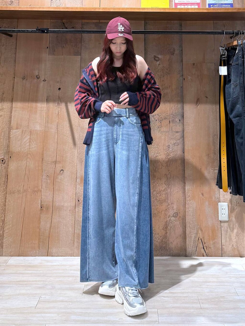 ブルー系のデニムパンツ、シルバー系のスニーカー、ブラック系のタンクトップを着用したレディースの夏コーディネートの4枚目の写真