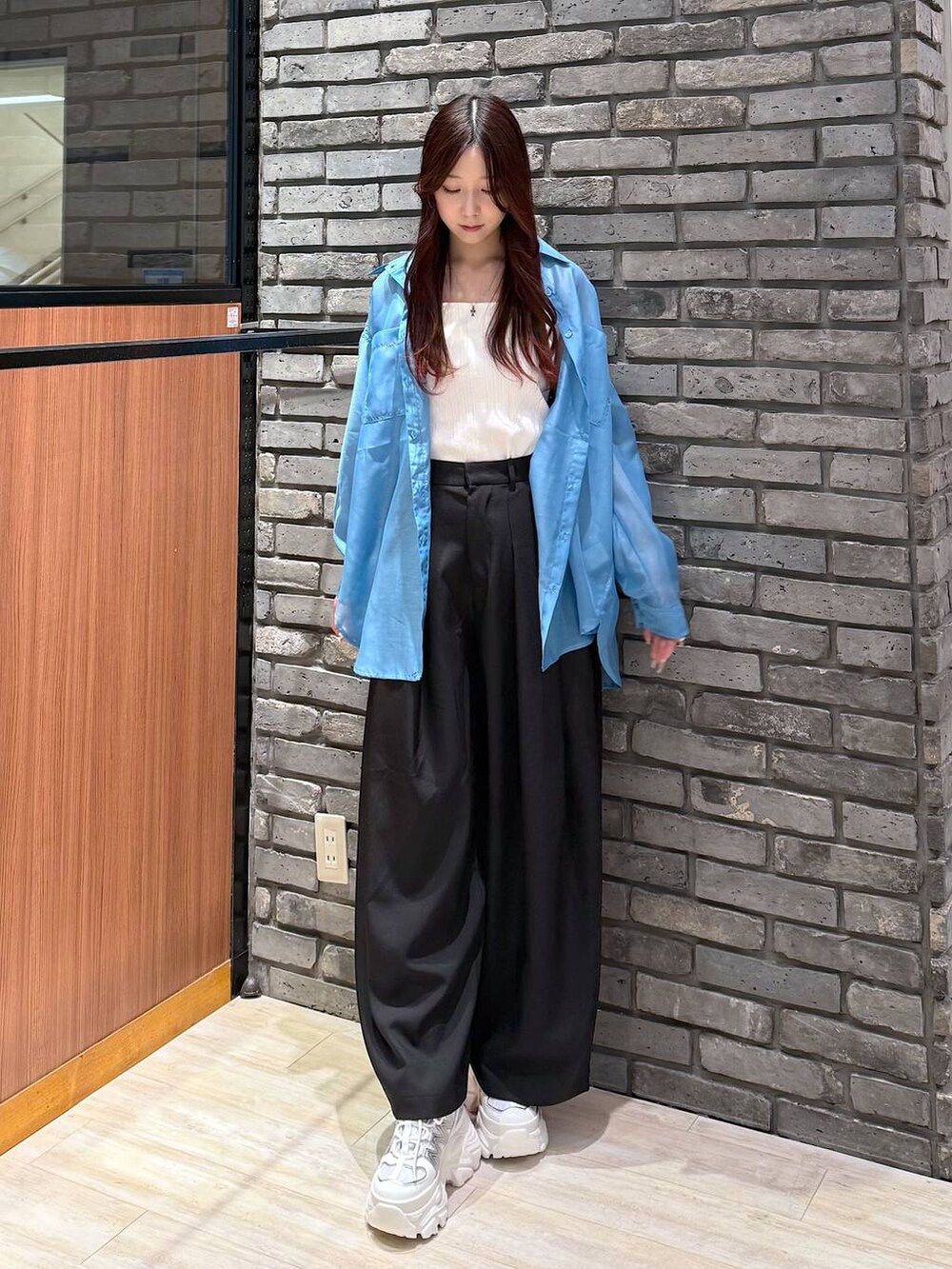 ホワイト系のスニーカー、ホワイト系のタンクトップ、ブラック系のスラックスを着用したレディースの春コーディネートの2枚目の写真