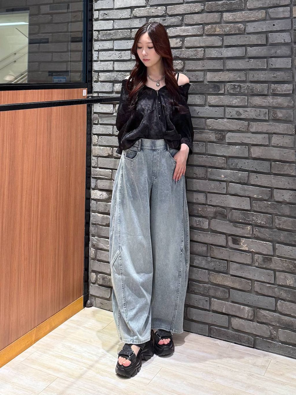 ブルー系のデニムパンツ、ブラック系のサンダル、ブラック系のシャツ/ブラウスを着用したレディースの夏コーディネートの2枚目の写真