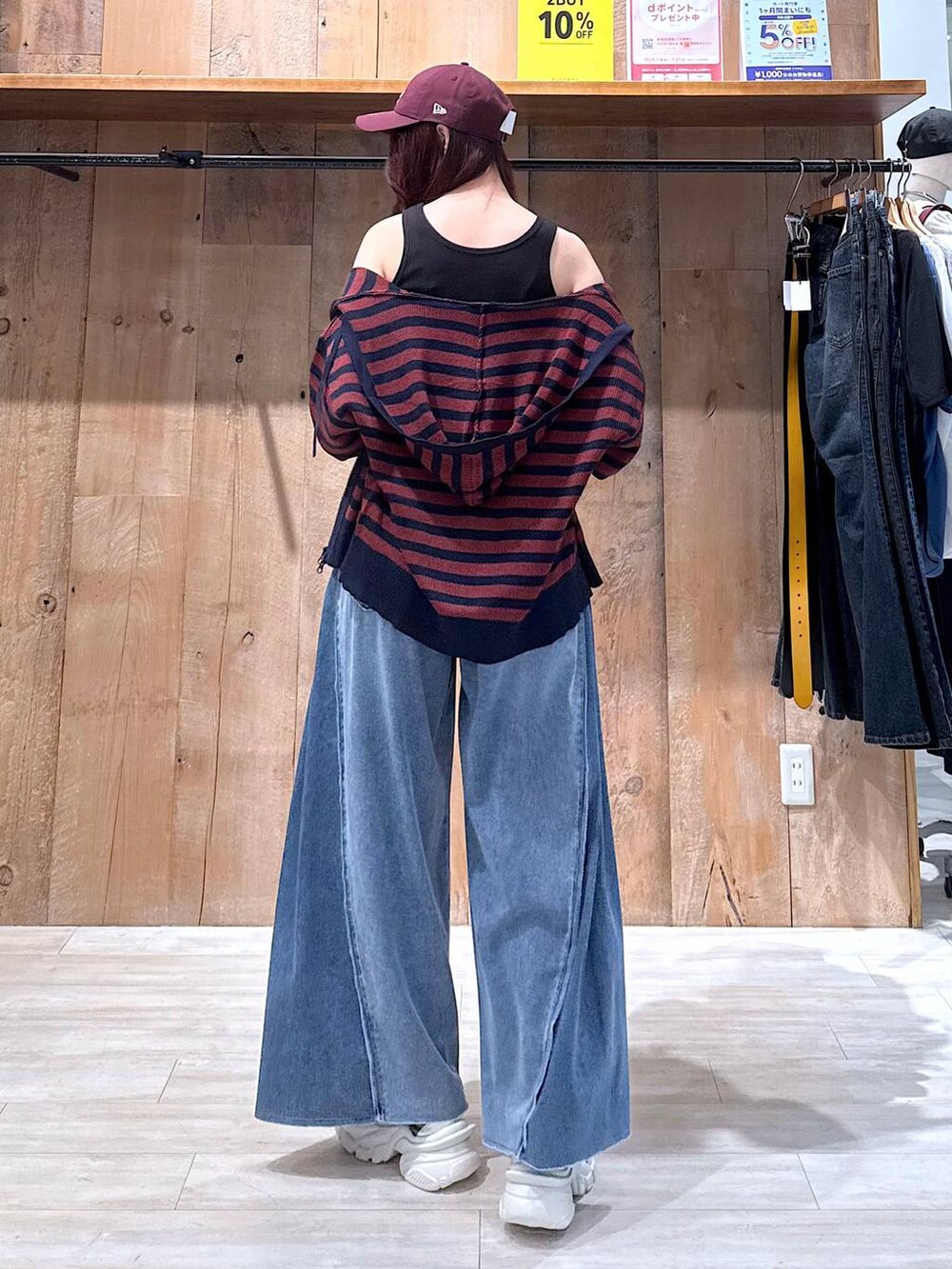 ブルー系のデニムパンツ、シルバー系のスニーカー、ブラック系のタンクトップを着用したレディースの夏コーディネートの3枚目の写真