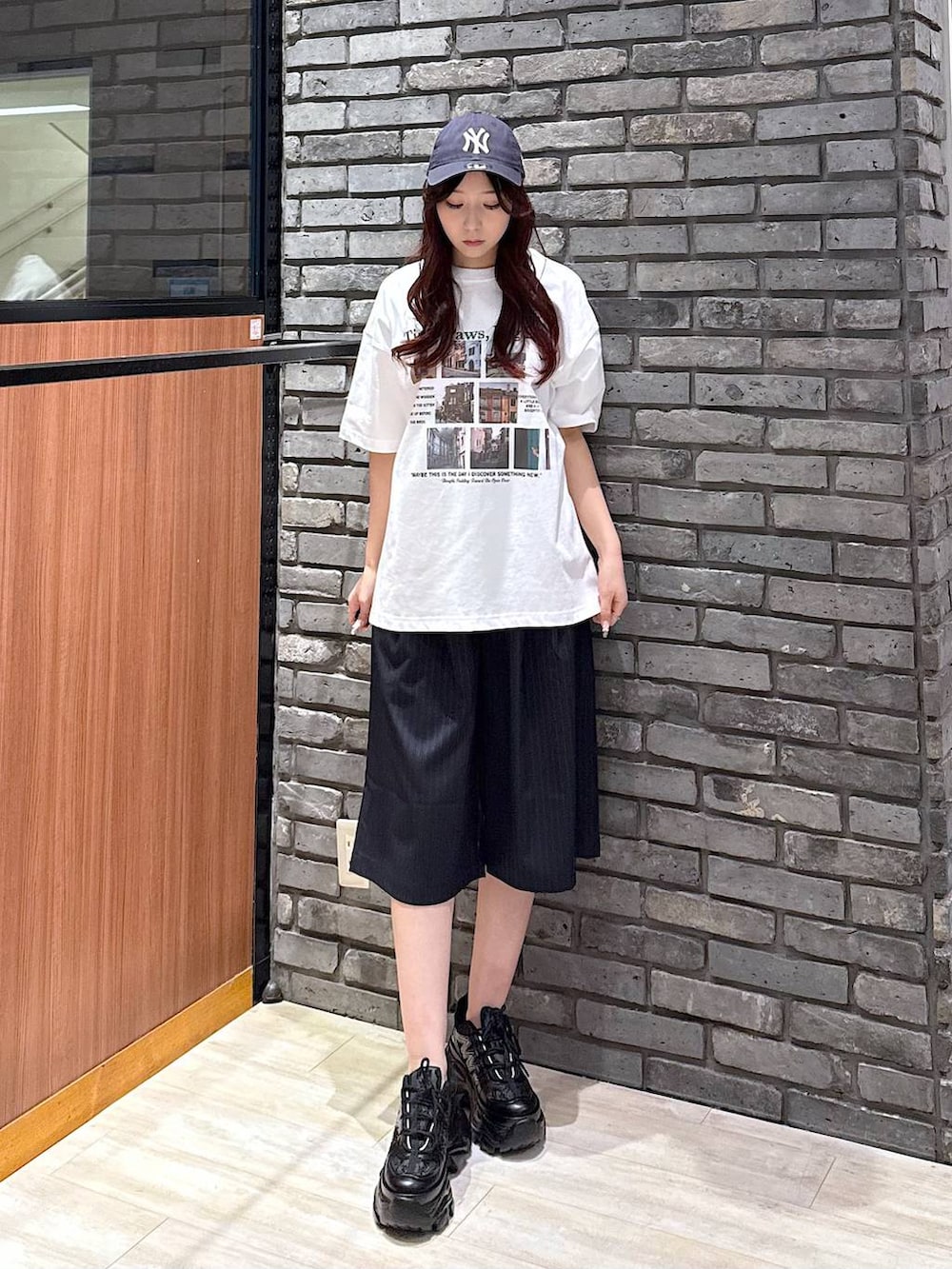 ブラック系のスニーカー、ホワイト系のTシャツ/カットソー、ブルー系のスラックスを着用したレディースの春コーディネートの2枚目の写真