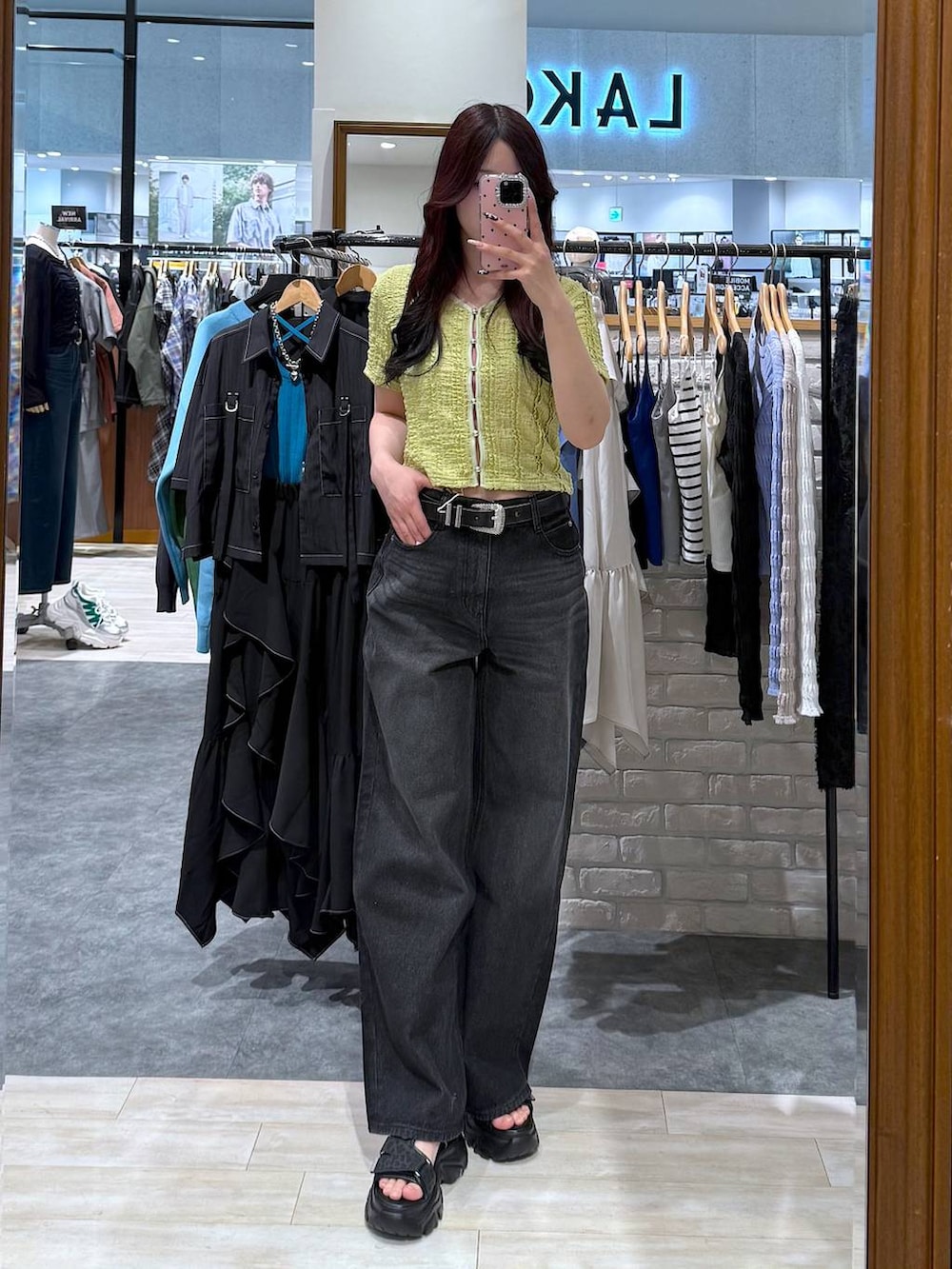 ブラック系のデニムパンツ、グリーン系のシャツ/ブラウス、ブラック系のベルトを着用したレディースの春コーディネートの5枚目の写真