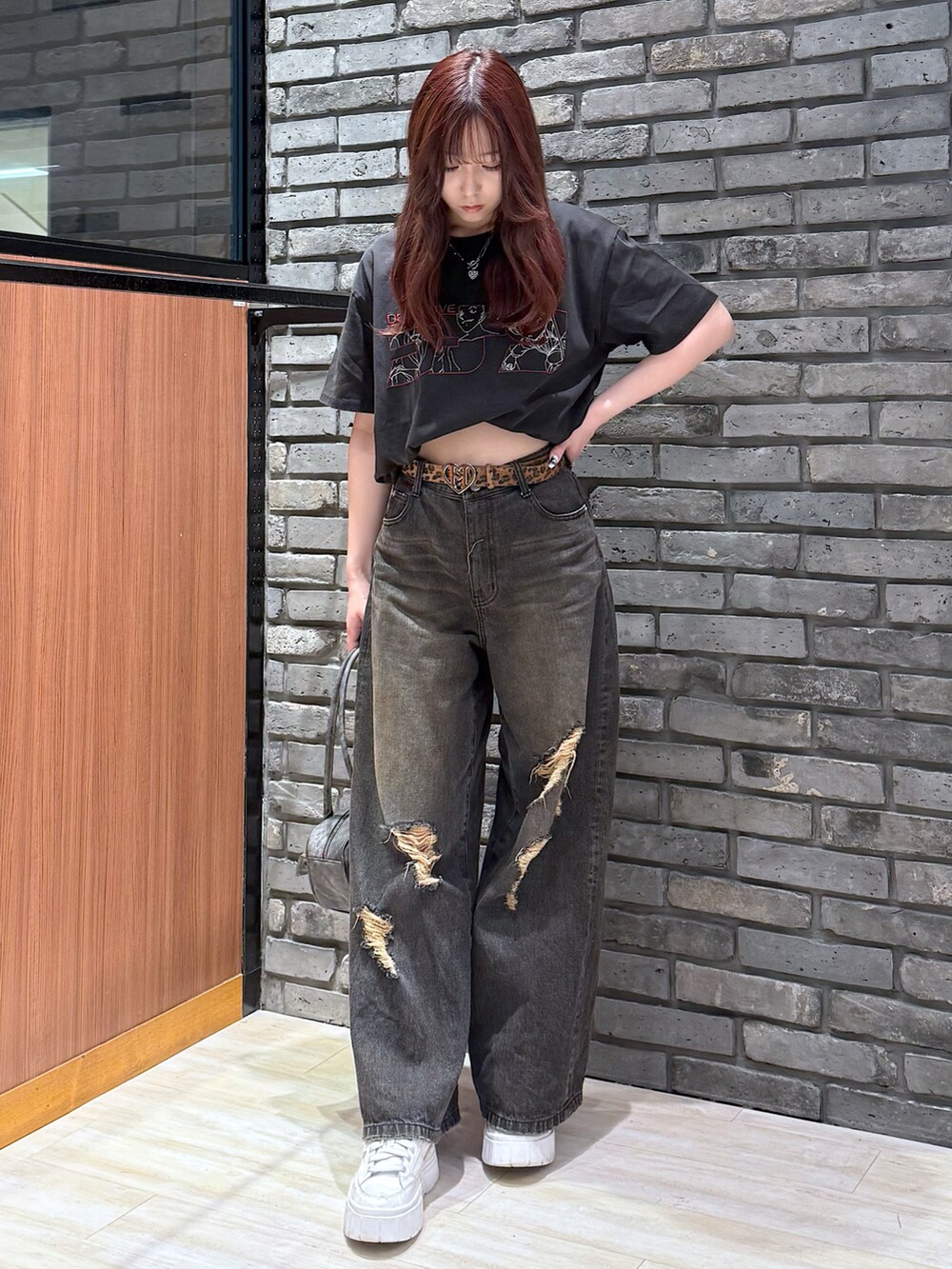 ブラック系のデニムパンツ、ブラック系のボストンバッグを着用したレディースの春コーディネートの4枚目の写真