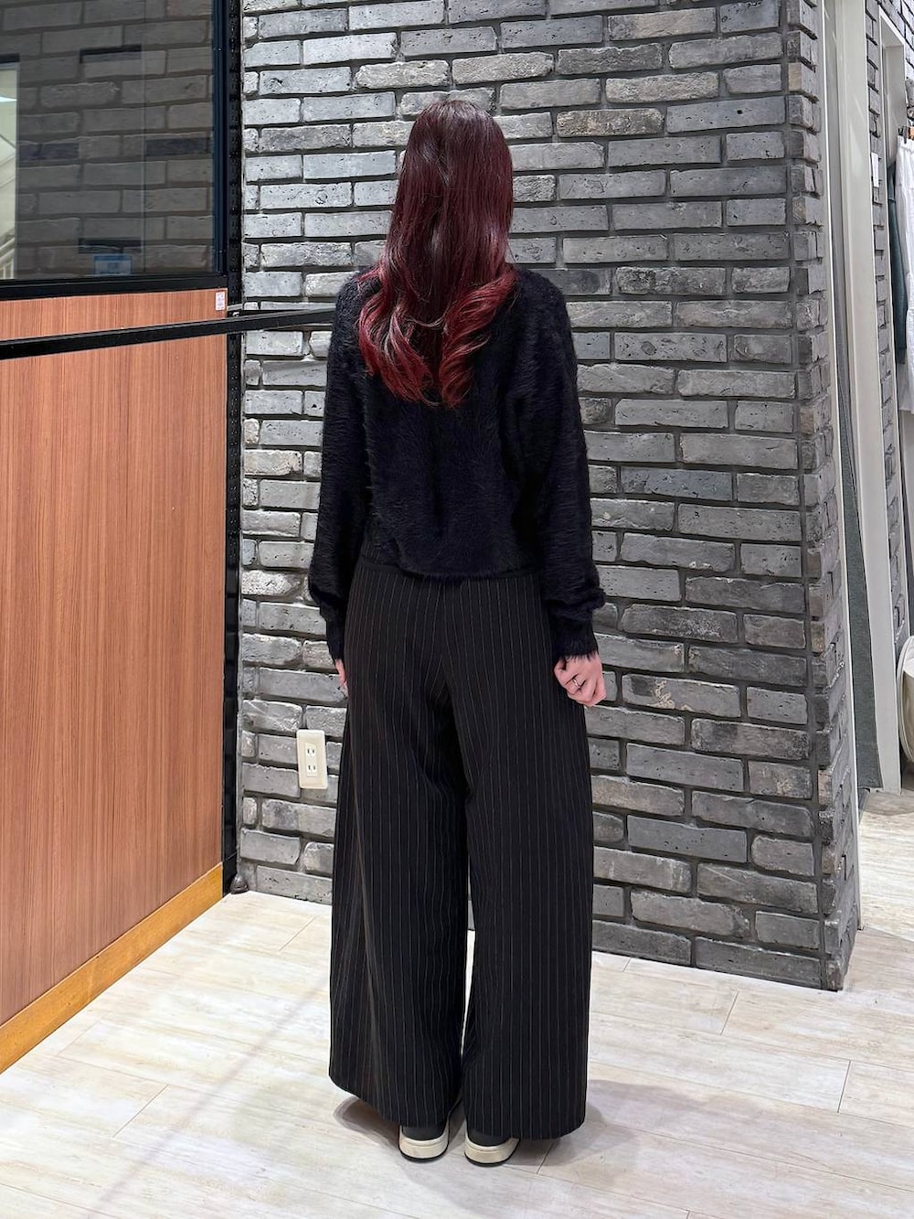 ピンク系のハンドバッグ、ブラック系のスラックス、ブラック系のニット/セーターを着用したレディースの冬コーディネートの5枚目の写真