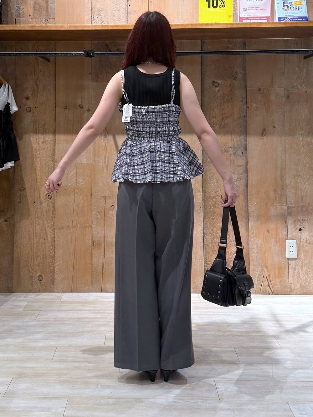 ブラック系のサンダル、グレー系のスラックス、ブラック系のショルダーバッグを着用したレディースの夏コーディネートの5枚目の写真