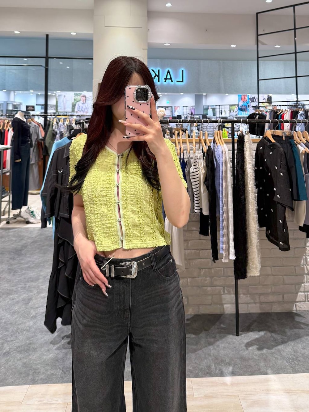 ブラック系のデニムパンツ、グリーン系のシャツ/ブラウス、ブラック系のベルトを着用したレディースの春コーディネートの2枚目の写真