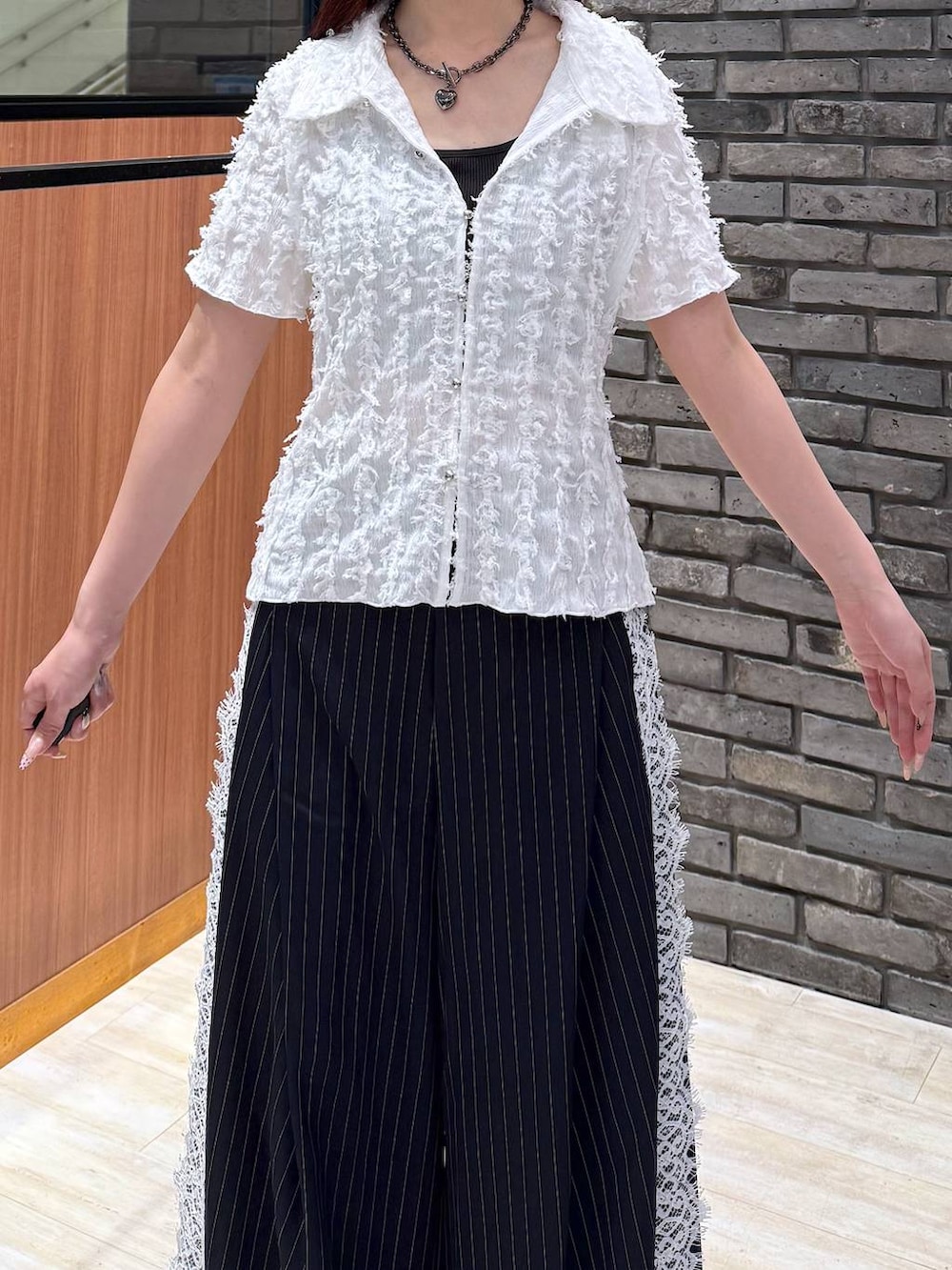 ブラック系のサンダル、ブルー系のスラックス、ホワイト系のシャツ/ブラウスを着用したレディースの夏コーディネートの3枚目の写真