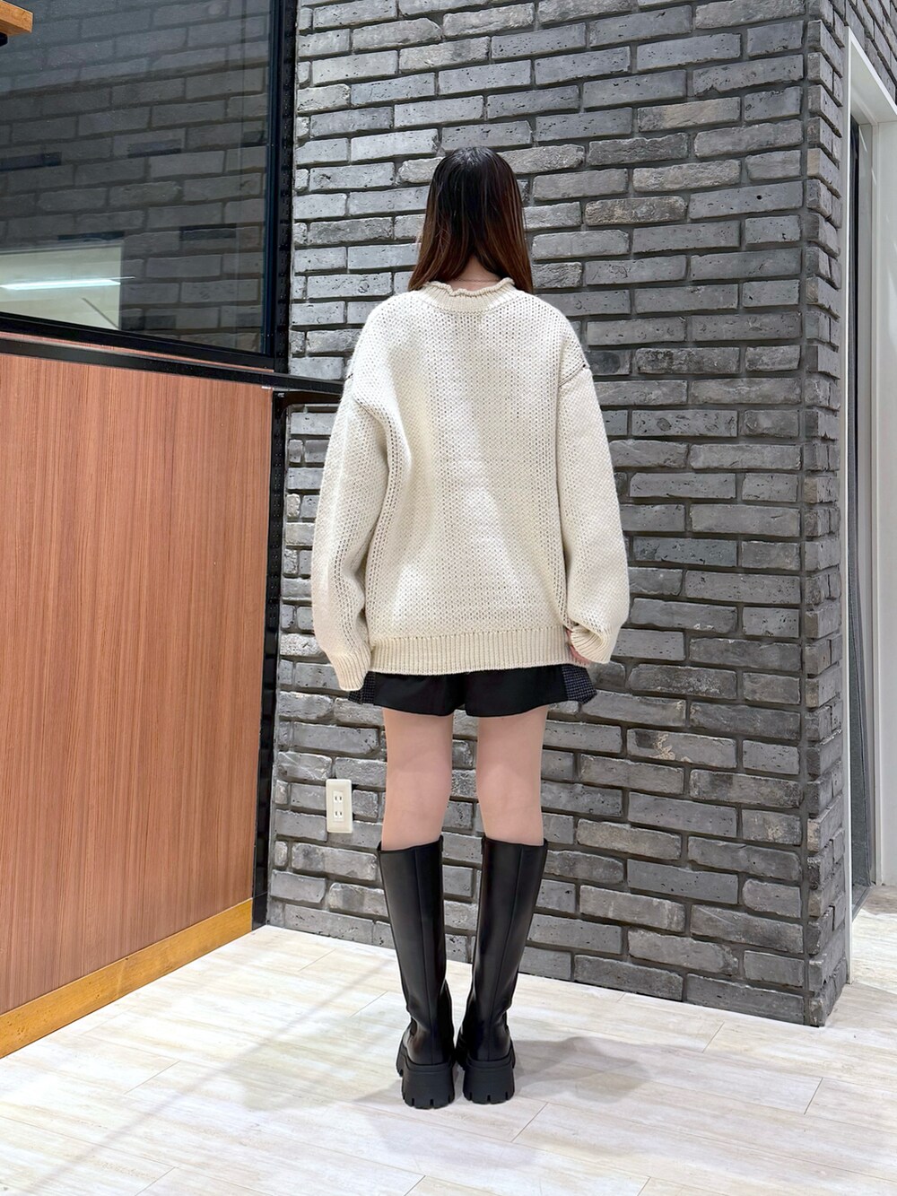 ホワイト系のニット/セーター、ブラック系のその他パンツ、ブラック系のブーツを着用したレディースの冬コーディネートの4枚目の写真