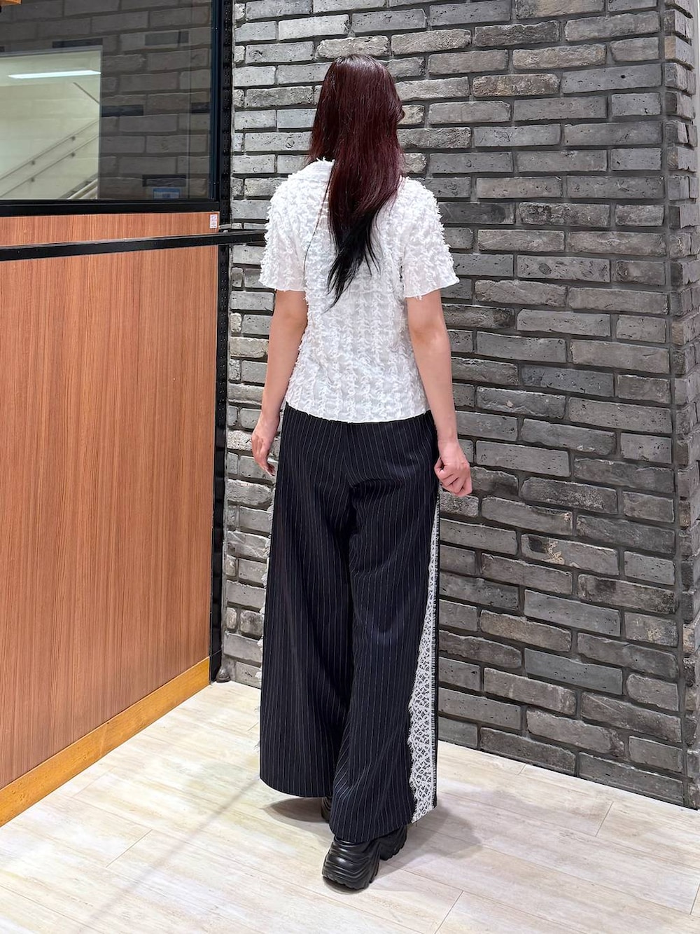 ブラック系のサンダル、ブルー系のスラックス、ホワイト系のシャツ/ブラウスを着用したレディースの夏コーディネートの5枚目の写真
