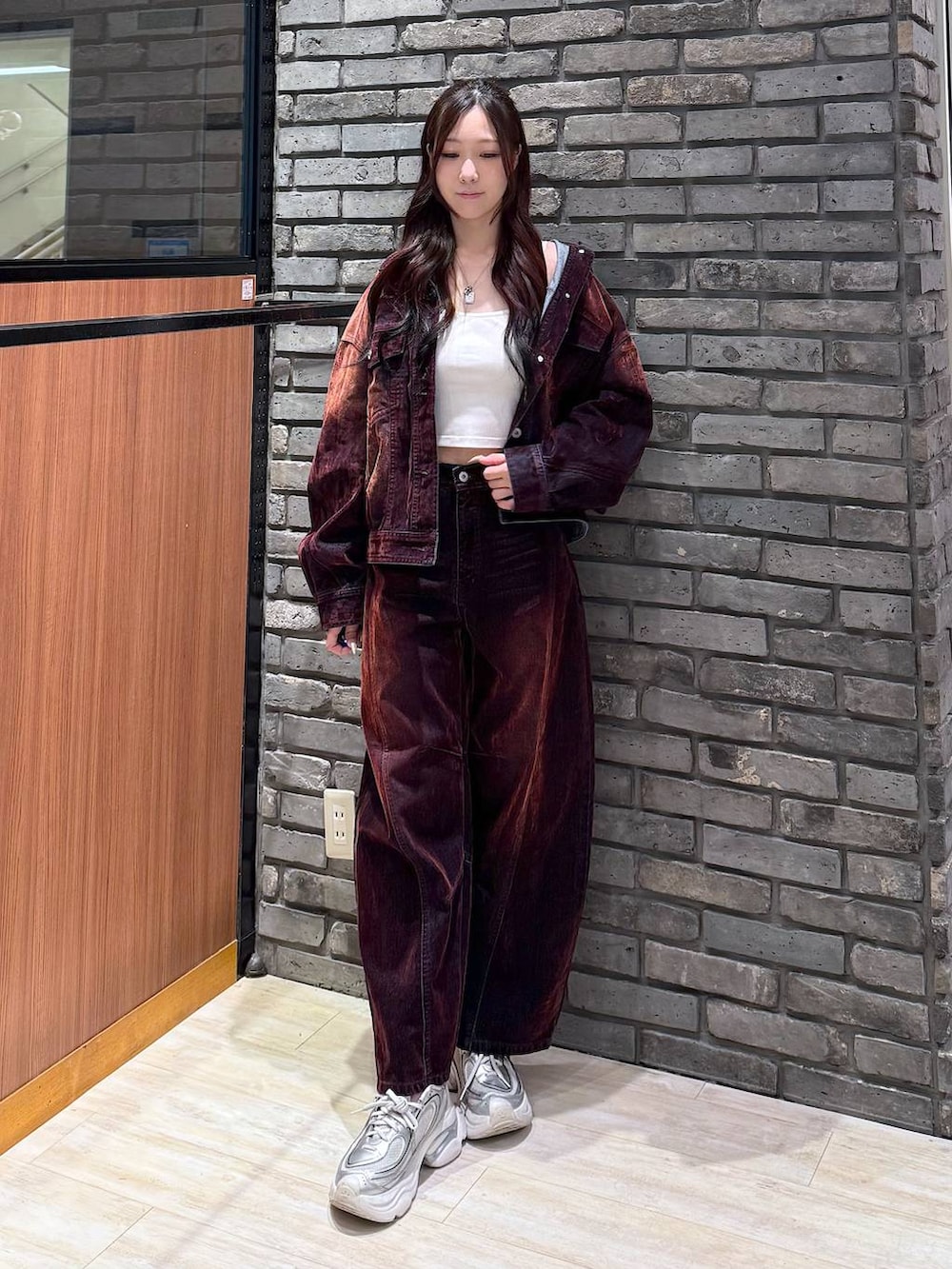 レッド系のデニムパンツ、レッド系のデニムジャケットを着用したレディースの秋コーディネートの2枚目の写真