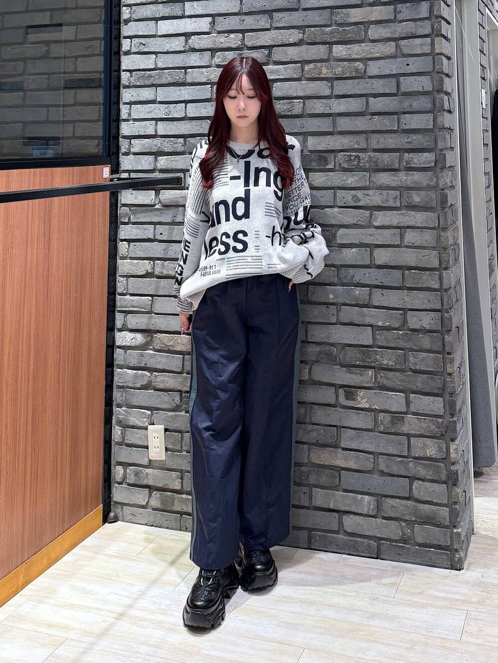 ブラック系のスニーカー、ブルー系のスウェットパンツ、グレー系のニット/セーターを着用したレディースの冬コーディネートの2枚目の写真