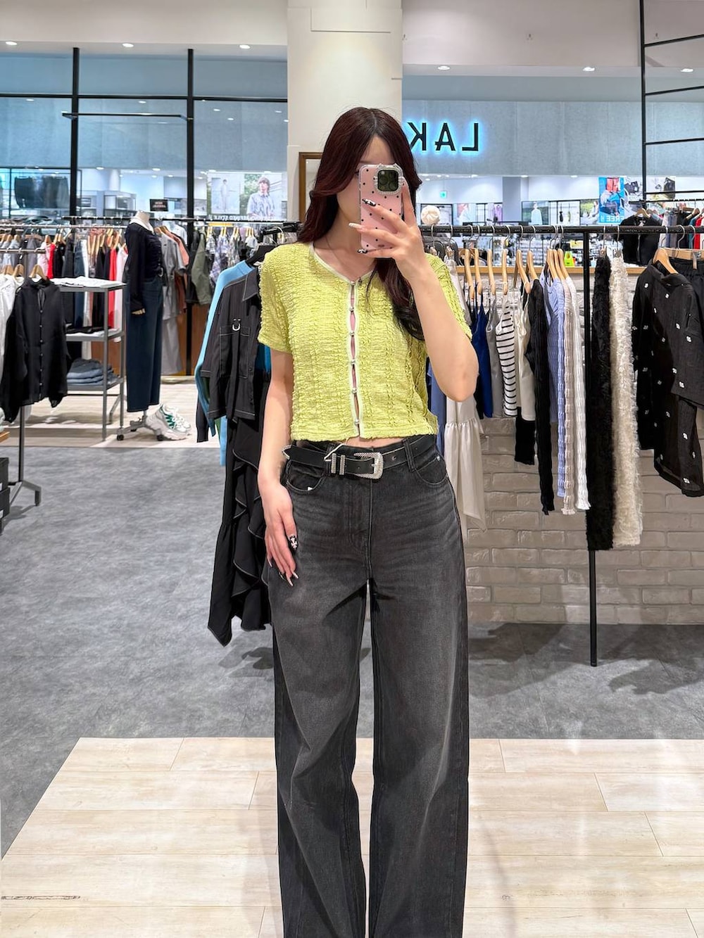 ブラック系のデニムパンツ、グリーン系のシャツ/ブラウス、ブラック系のベルトを着用したレディースの春コーディネートの4枚目の写真