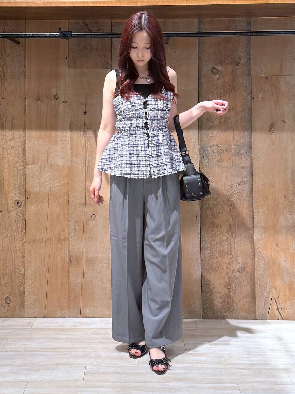 ブラック系のサンダル、グレー系のスラックス、ブラック系のショルダーバッグを着用したレディースの夏コーディネートの4枚目の写真