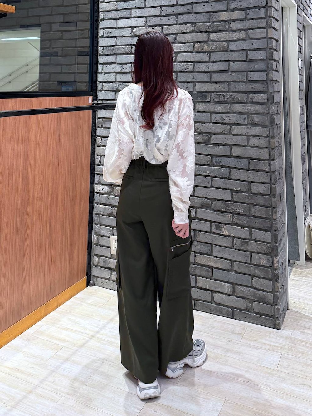 グリーン系のスラックス、ホワイト系のTシャツ/カットソーを着用したレディースの冬コーディネートの3枚目の写真