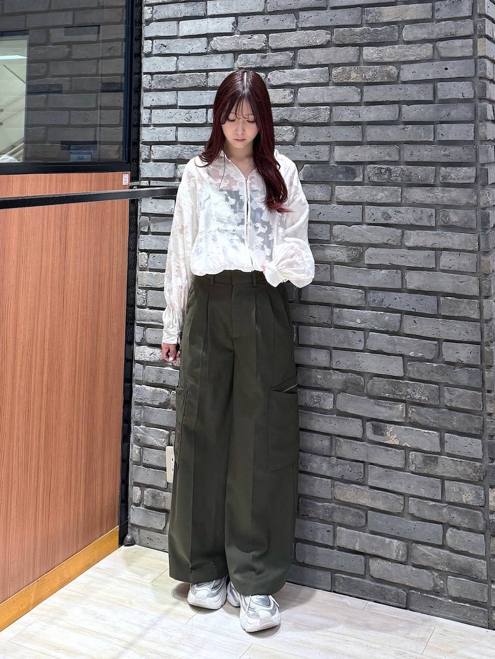 グリーン系のスラックス、ホワイト系のTシャツ/カットソーを着用したレディースの冬コーディネートの2枚目の写真