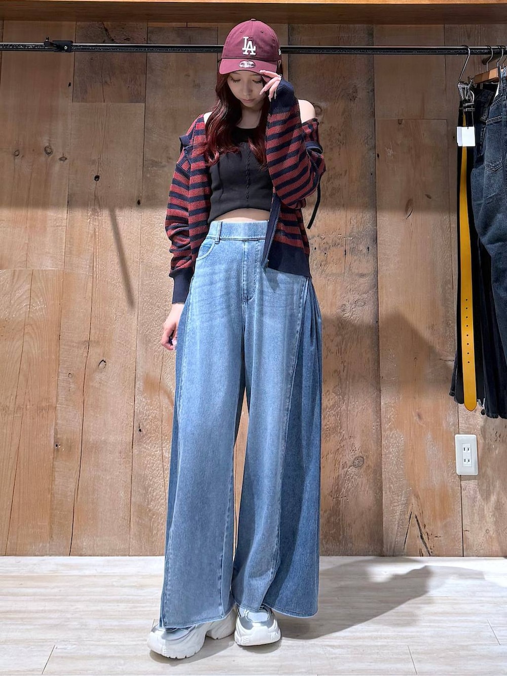 ブルー系のデニムパンツ、シルバー系のスニーカー、ブラック系のタンクトップを着用したレディースの夏コーディネートの5枚目の写真