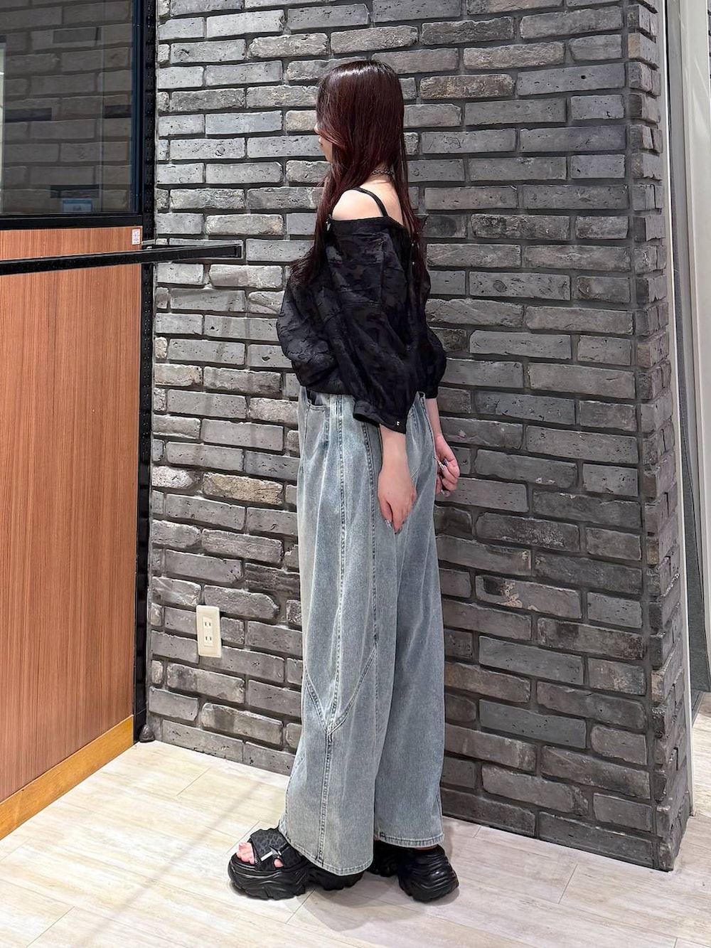 ブルー系のデニムパンツ、ブラック系のサンダル、ブラック系のシャツ/ブラウスを着用したレディースの夏コーディネートの3枚目の写真