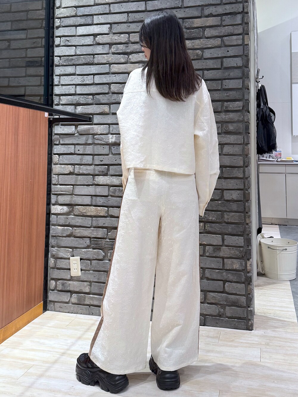 ホワイト系のシャツ/ブラウス、ホワイト系のパンツ、ブラック系のスニーカーを着用したレディースの冬コーディネートの3枚目の写真