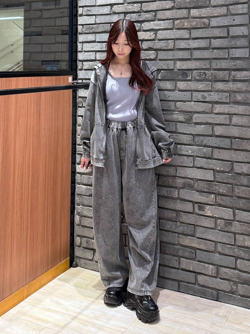 ブラック系のスニーカー、ブラック系のデニムパンツ、ブラック系のパーカーを着用したレディースの春コーディネートの2枚目の写真