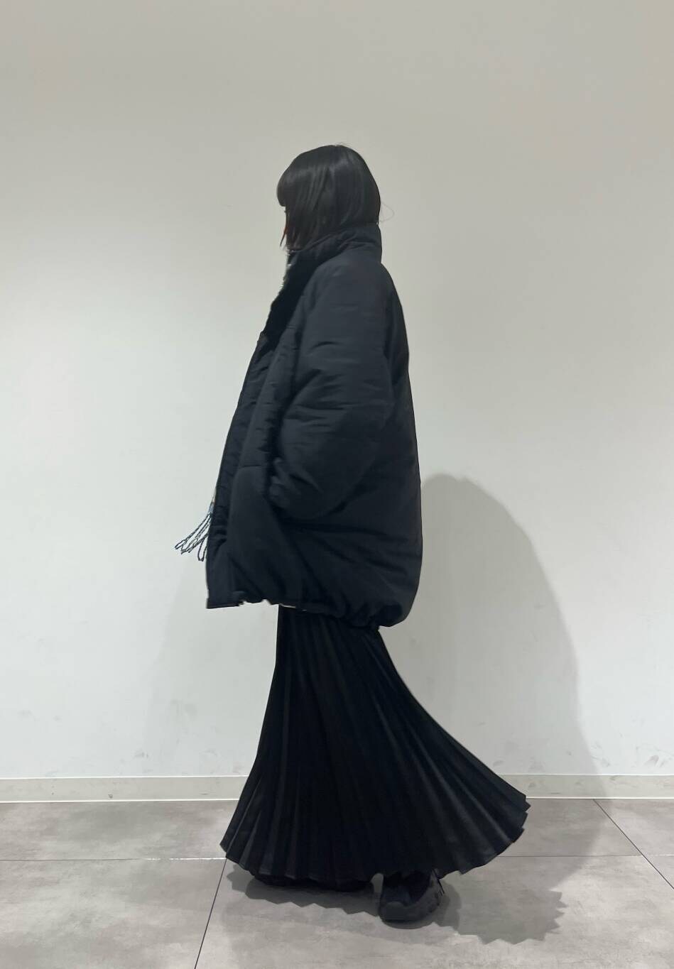 グレー系のTシャツ/カットソー、ブラック系のスニーカー、ブラック系のダウンジャケット/コートを着用したレディースの冬コーディネートの2枚目の写真