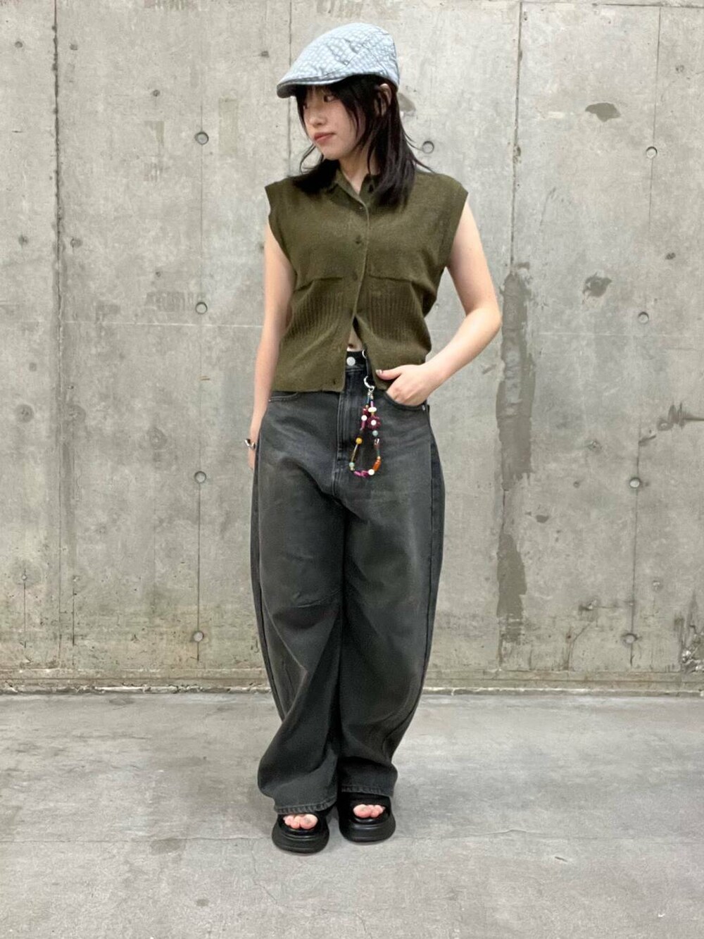 グレー系のデニムパンツ、ブラック系のサンダル、ブラウン系のニット/セーターを着用したレディースの夏コーディネートの3枚目の写真