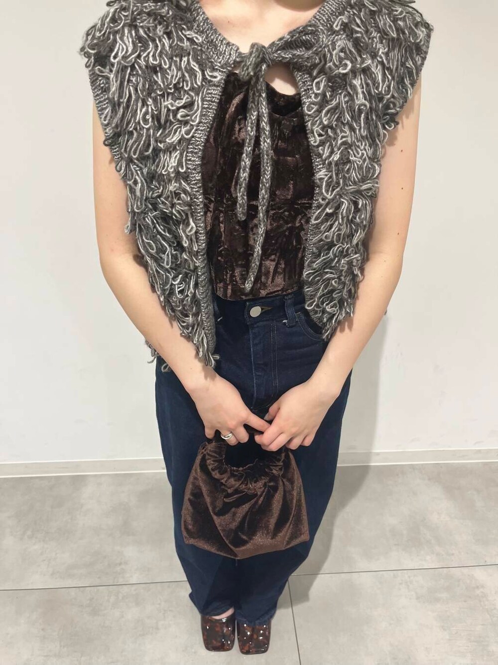 ブルー系のデニムパンツ、ブラウン系のキャミソール、ブラウン系のハンドバッグを着用したレディースの夏コーディネートの3枚目の写真