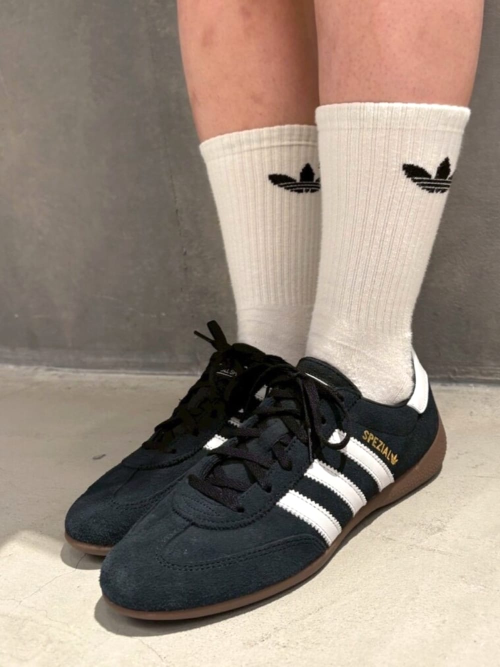 ブラック系のデニムジャケット、ホワイト系のスカート、ブラック系のスニーカーを着用したレディースの冬コーディネートの4枚目の写真