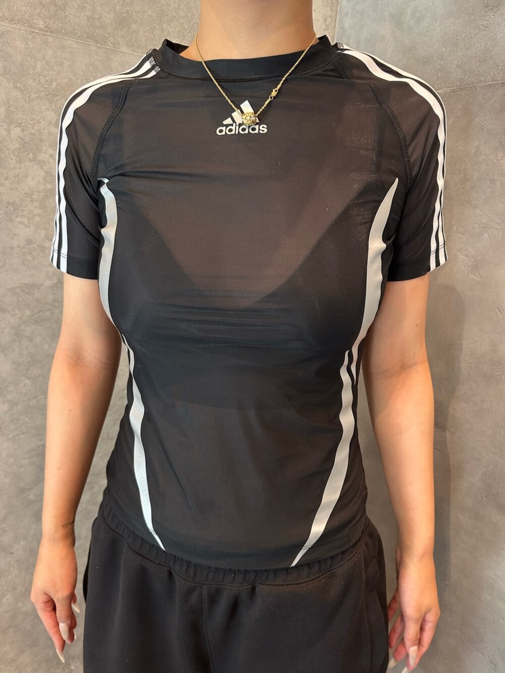 ブラック系のTシャツ/カットソー、ブラック系のスニーカーを着用したレディースの夏コーディネートの2枚目の写真