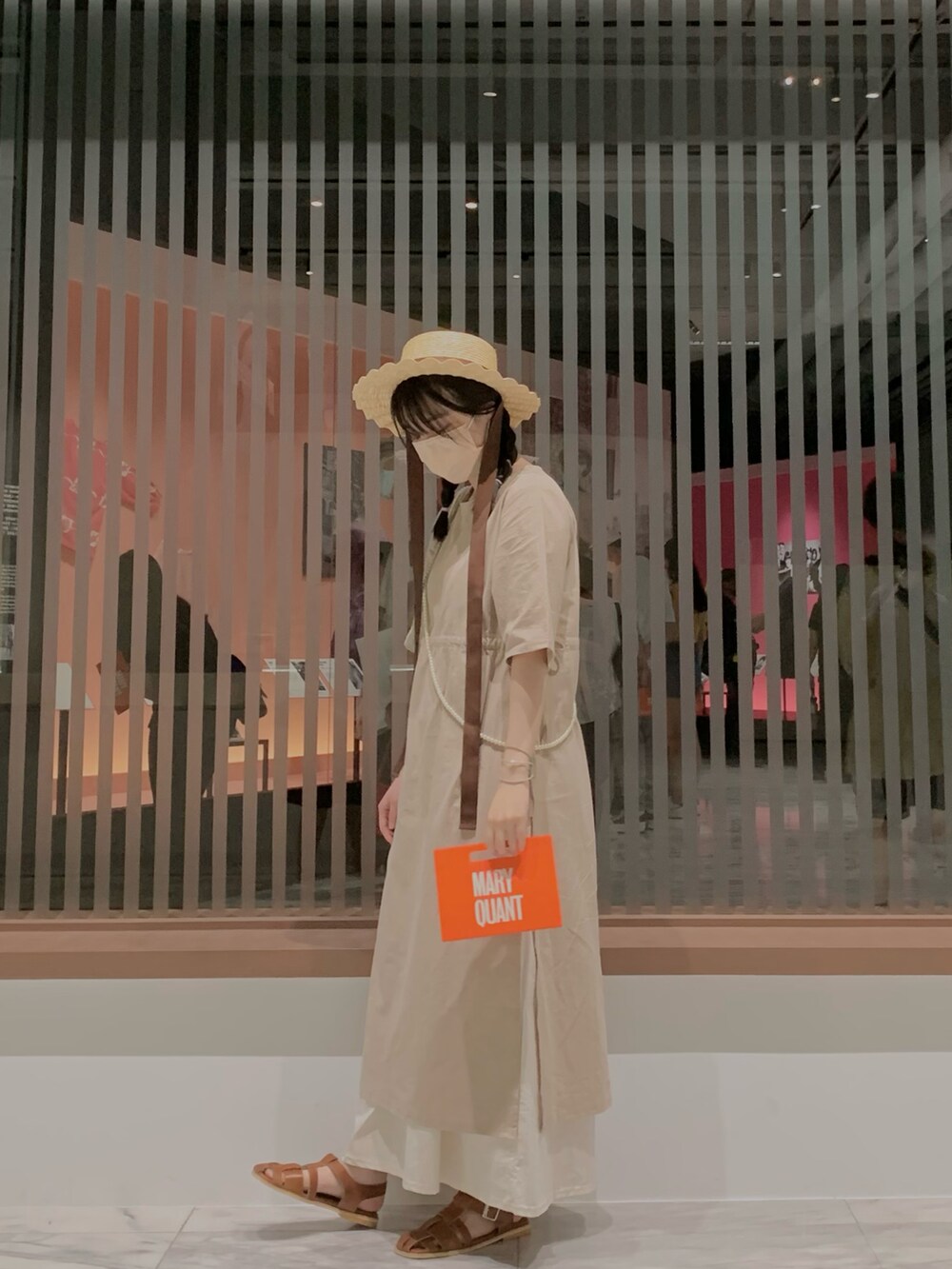 ブラウン系のハットを着用したレディースの夏コーディネートの2枚目の写真