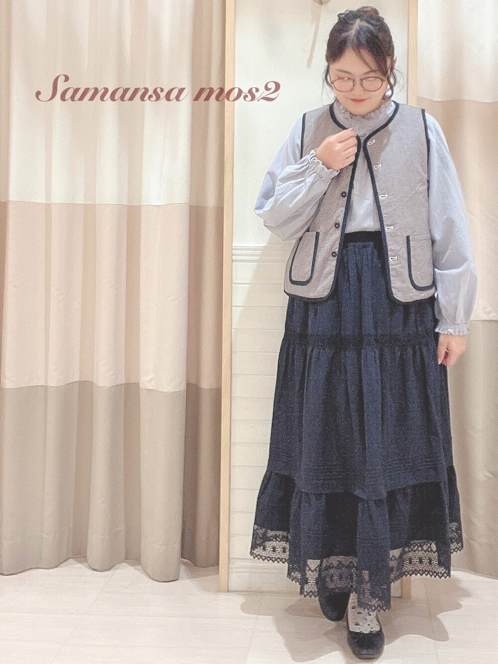 ブラック系のベスト、ブルー系のシャツ/ブラウス、ブラック系のスカートを着用したレディースの秋コーディネートの2枚目の写真