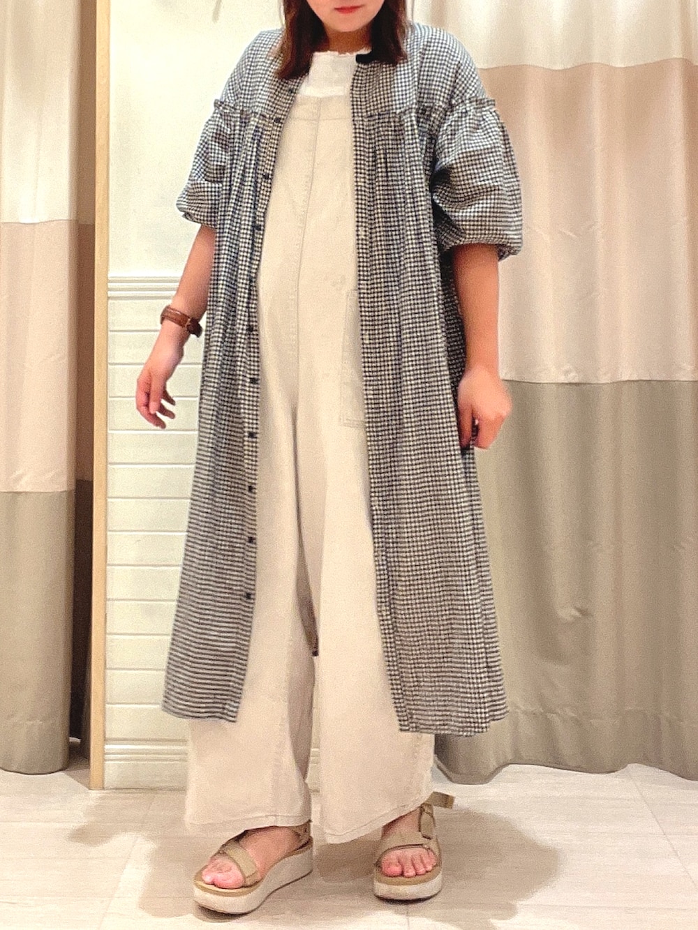 ベージュ系のサロペット/オーバーオール、ブラック系のワンピース、ベージュ系のサンダルを着用したレディースの夏コーディネートの2枚目の写真