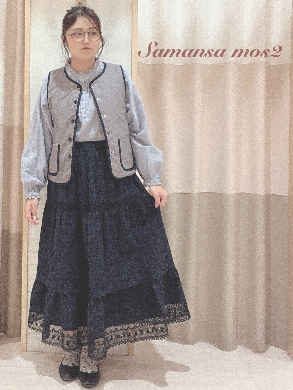 ブラック系のベスト、ブルー系のシャツ/ブラウス、ブラック系のスカートを着用したレディースの秋コーディネートの3枚目の写真