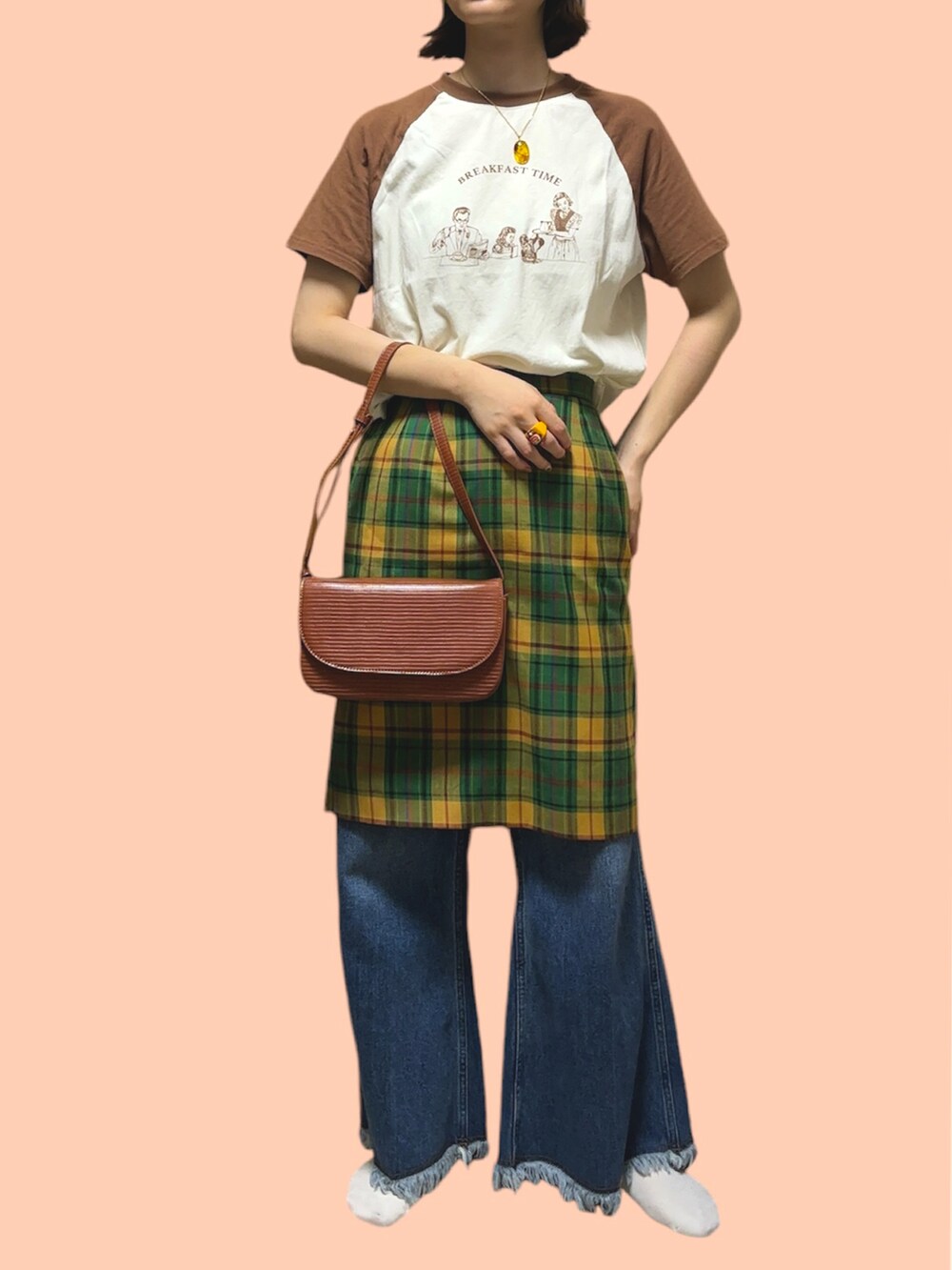 グリーン系のスカート、ブラウン系のショルダーバッグ、ブラウン系のTシャツ/カットソーを着用したレディースの秋コーディネートの2枚目の写真