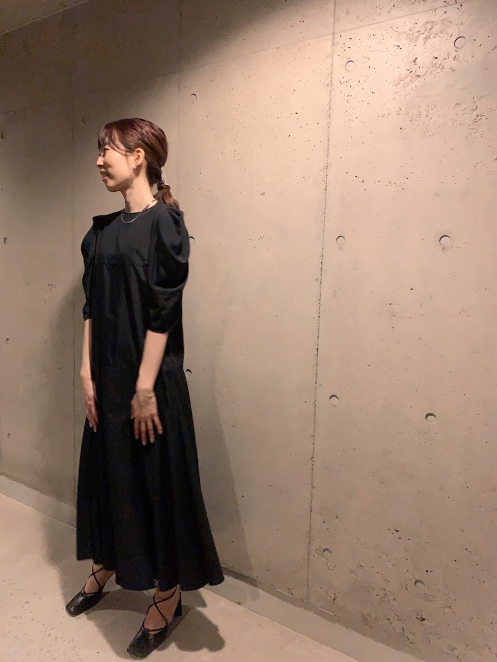 ブラック系のワンピース、ブラック系のパンプスを着用したレディースの春コーディネートの2枚目の写真