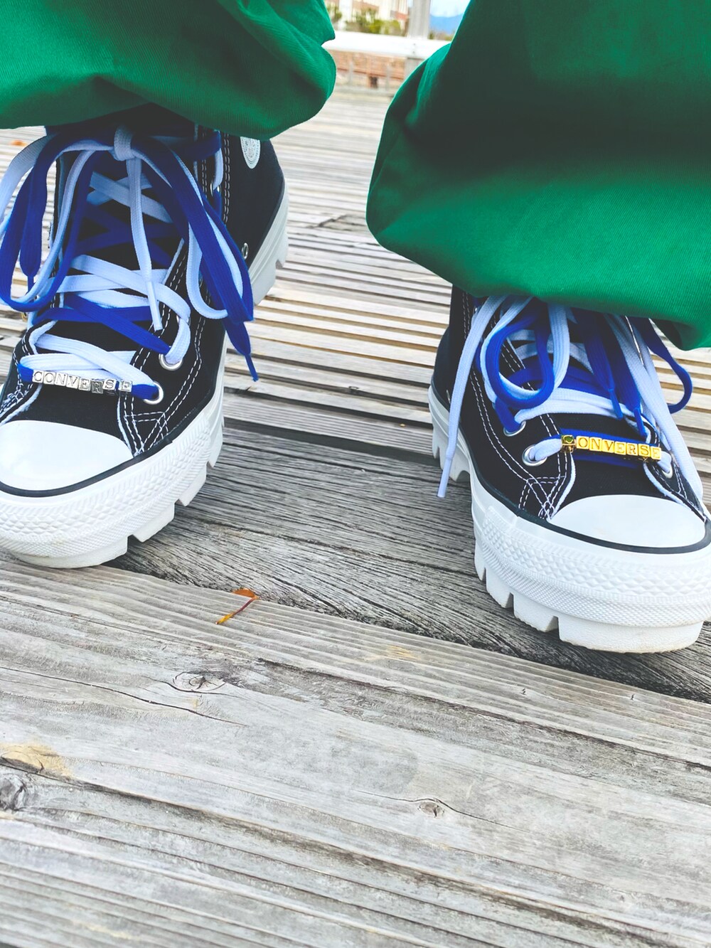 ホワイト系のトップス、グリーン系のカーゴパンツを着用したレディースの秋コーディネートの2枚目の写真