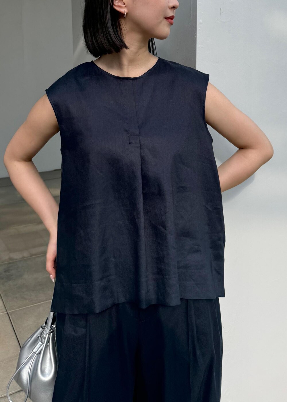 シルバー系のサンダル、シルバー系のハンドバッグ、ブルー系のシャツ/ブラウスを着用したレディースの夏コーディネートの6枚目の写真