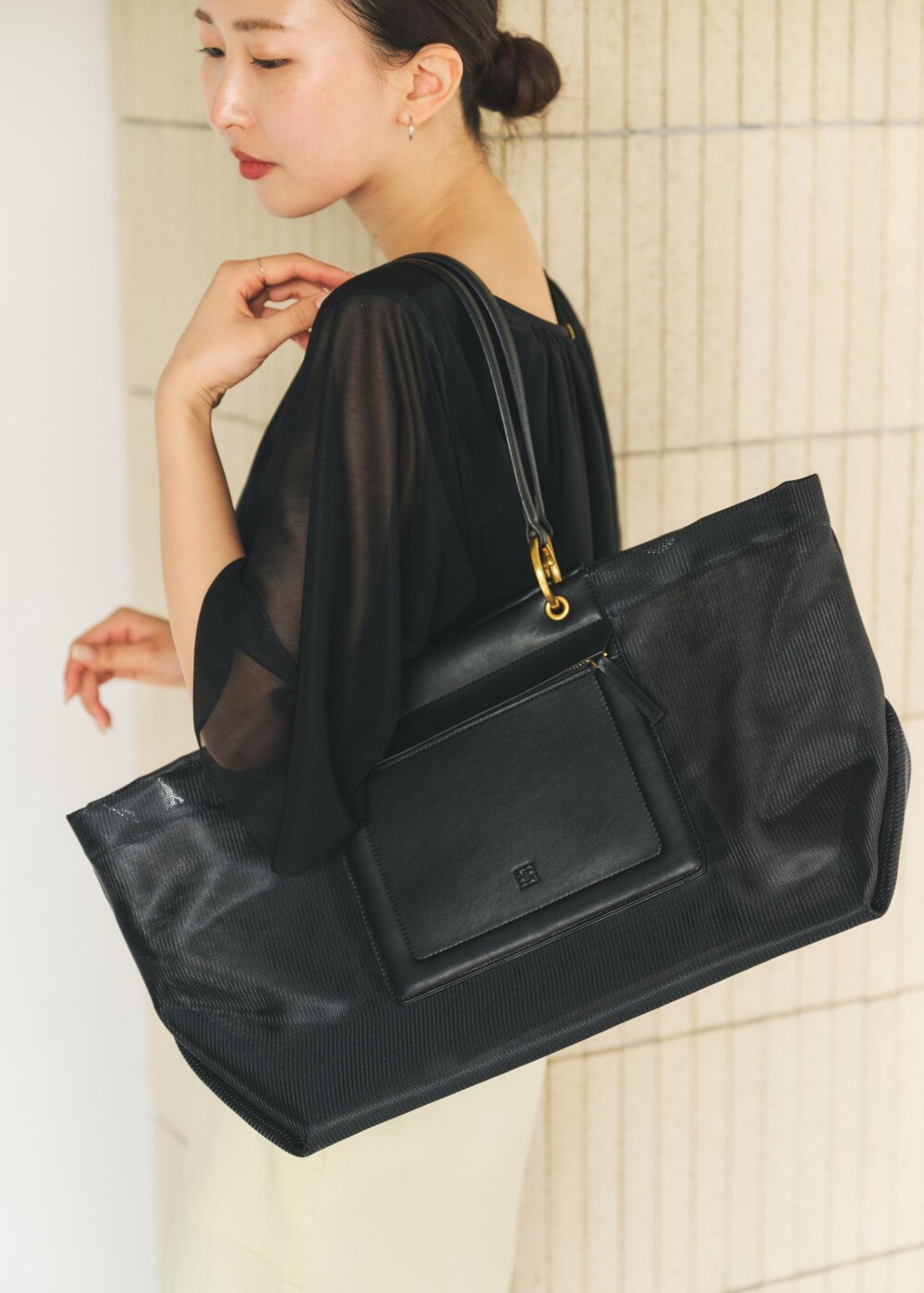 ブラック系のサンダル、ブラック系のトートバッグ、イエロー系のスカートを着用したレディースの春コーディネートの7枚目の写真