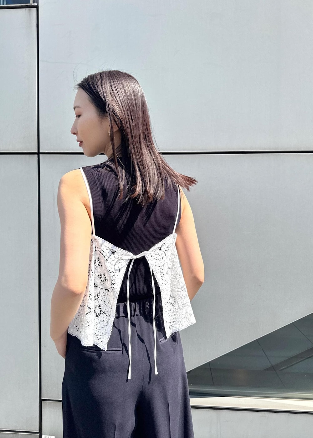 シルバー系のサンダル、ホワイト系のキャミソール、ブルー系のニット/セーターを着用したレディースの春コーディネートの6枚目の写真