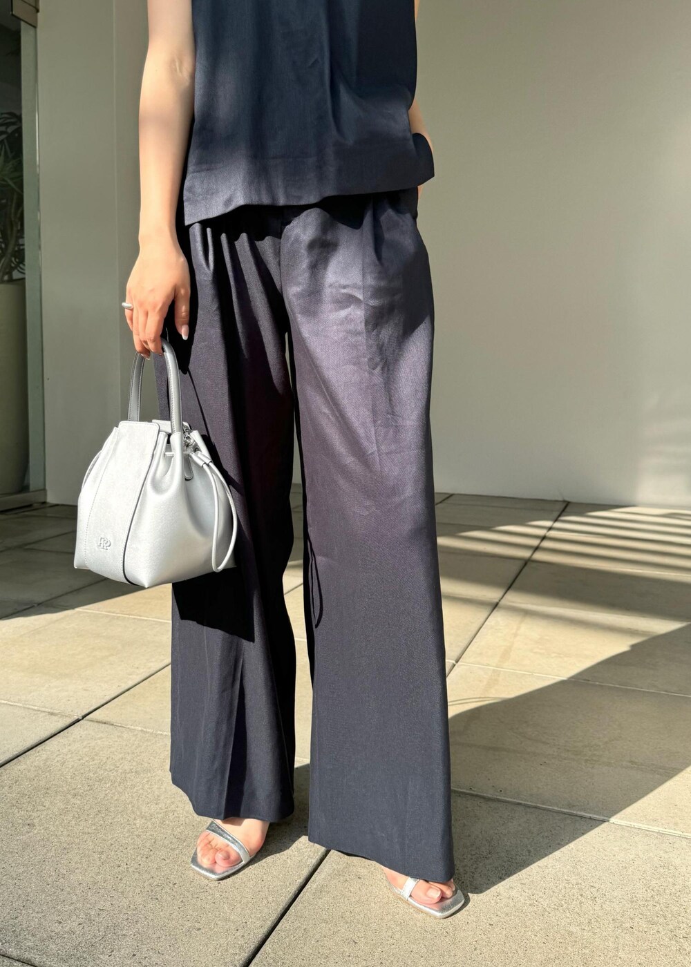 シルバー系のサンダル、シルバー系のハンドバッグ、ブルー系のシャツ/ブラウスを着用したレディースの夏コーディネートの9枚目の写真