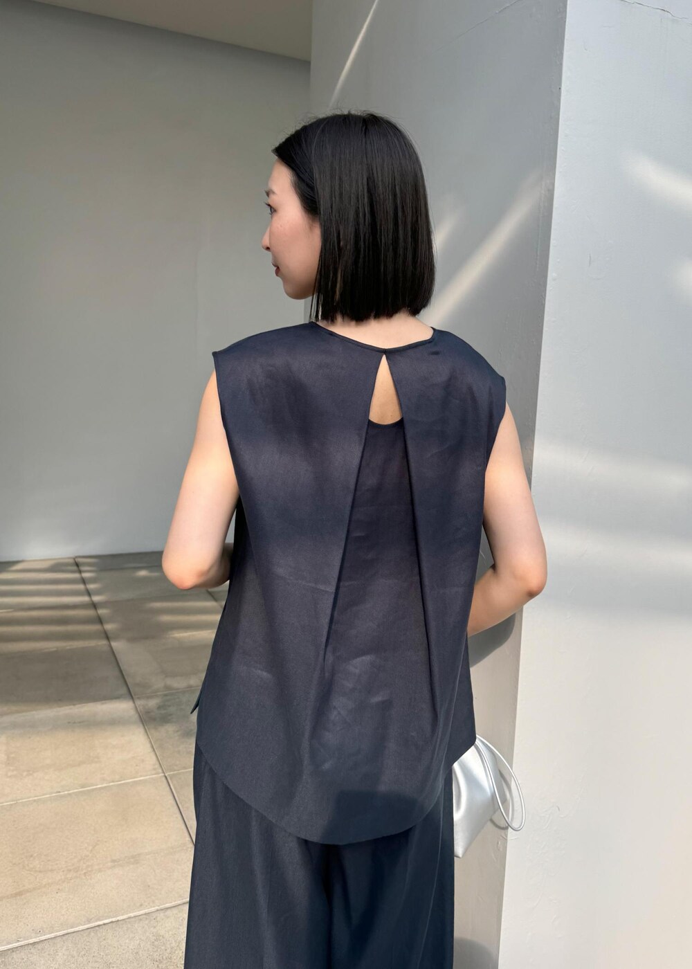 シルバー系のサンダル、シルバー系のハンドバッグ、ブルー系のシャツ/ブラウスを着用したレディースの夏コーディネートの8枚目の写真