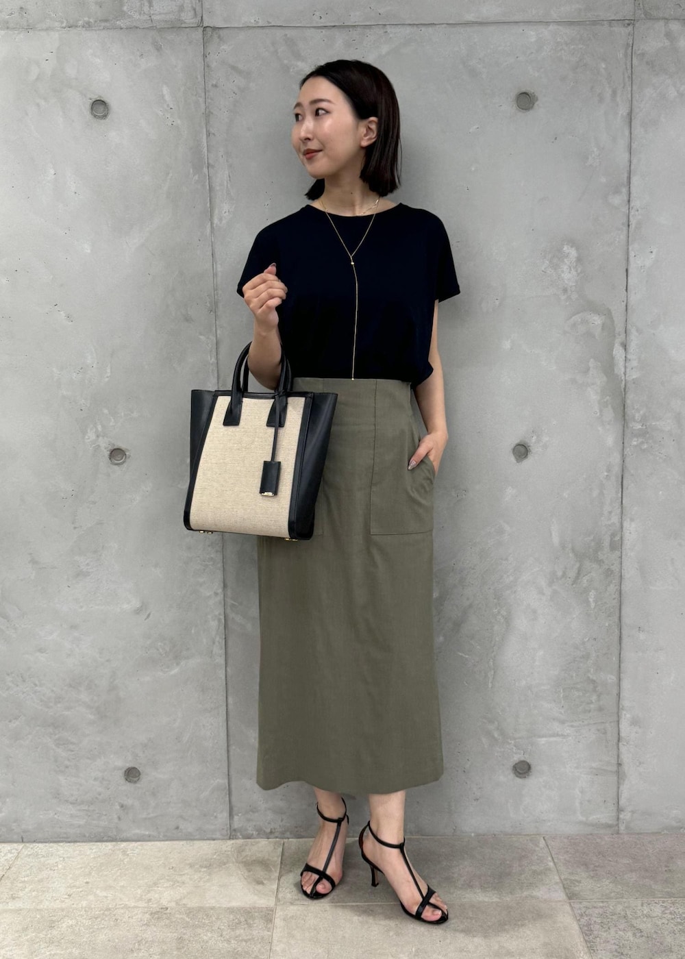 ブラック系のサンダル、グリーン系のスカート、ブラック系のTシャツ/カットソーを着用したレディースの夏コーディネートの4枚目の写真