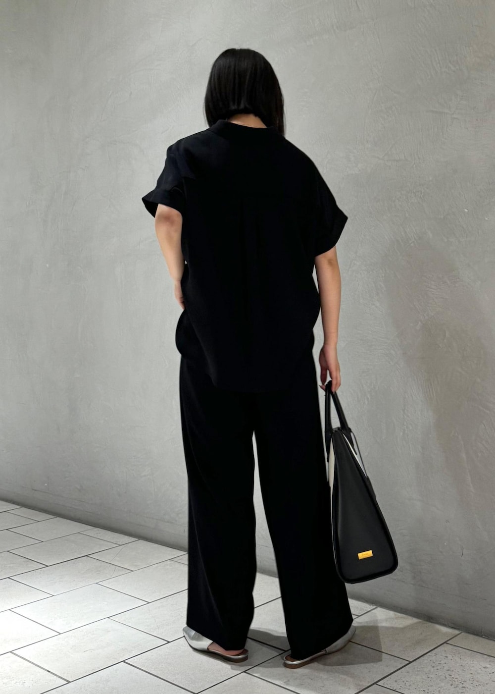 ブラック系のトートバッグ、シルバー系のパンプス、ブラック系のシャツ/ブラウスを着用したレディースの春コーディネートの4枚目の写真