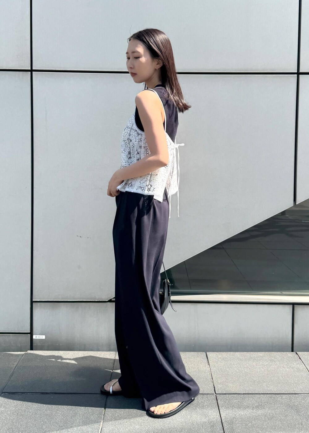 シルバー系のサンダル、ホワイト系のキャミソール、ブルー系のニット/セーターを着用したレディースの春コーディネートの2枚目の写真