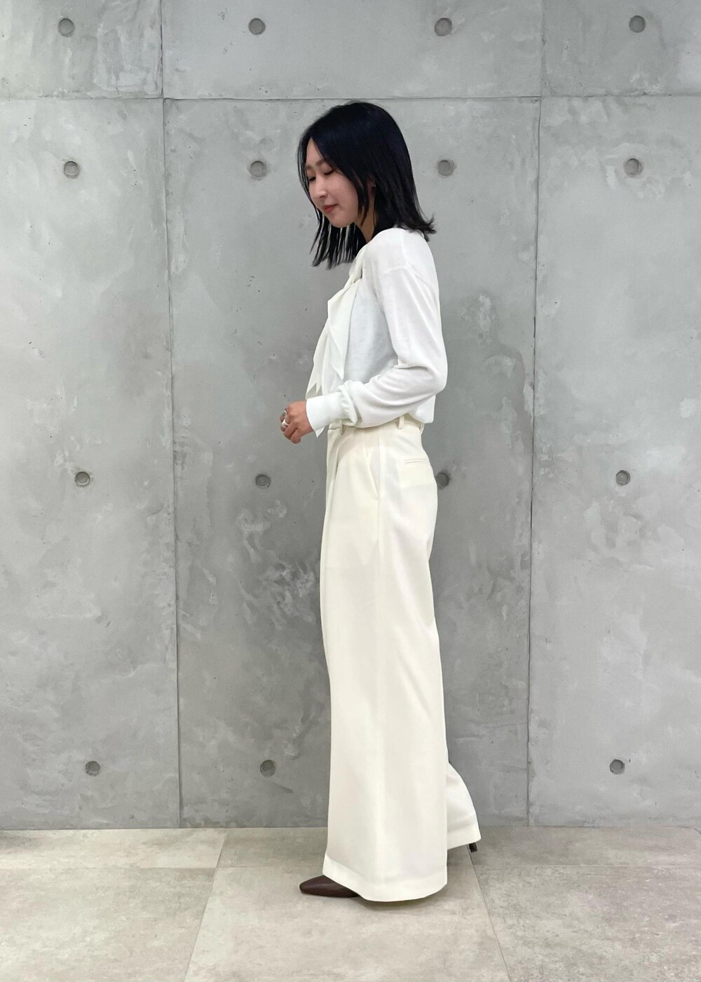 ブラウン系のハンドバッグ、ホワイト系のその他パンツ、ブラウン系のブーツを着用したレディースの秋コーディネートの3枚目の写真